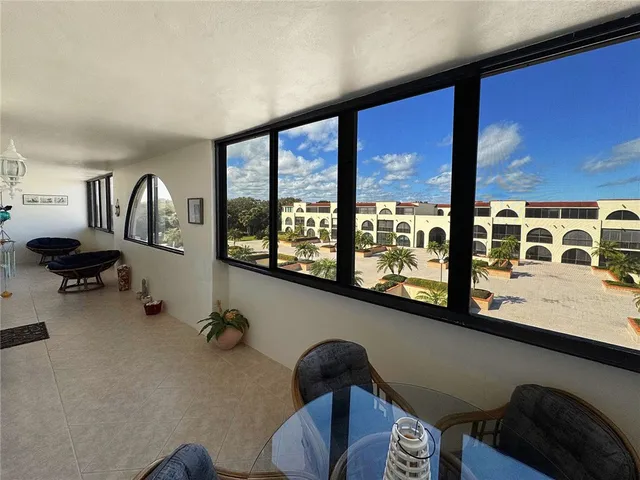 a view of workspace with furniture and floor to ceiling window