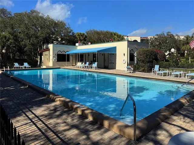 a view of a tennis ground with large trees