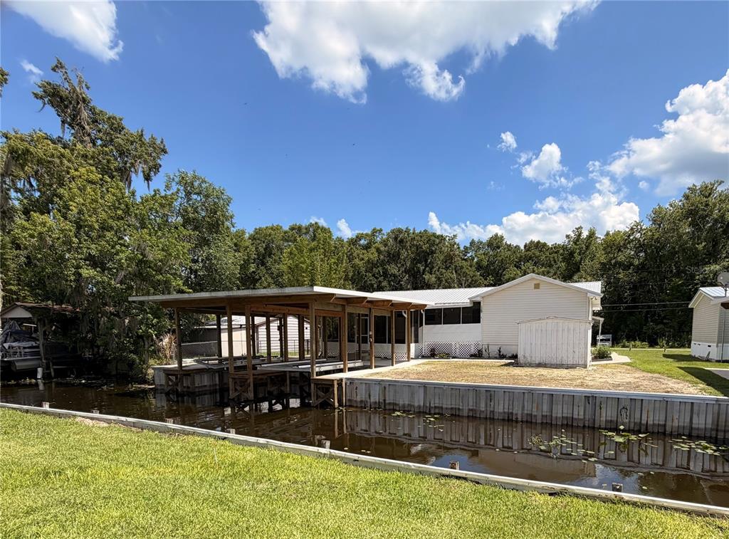 24521 Alligator Road Astor, FL 32102 - Photo 44 of 51 a view of a house with swimming pool and yard with green space