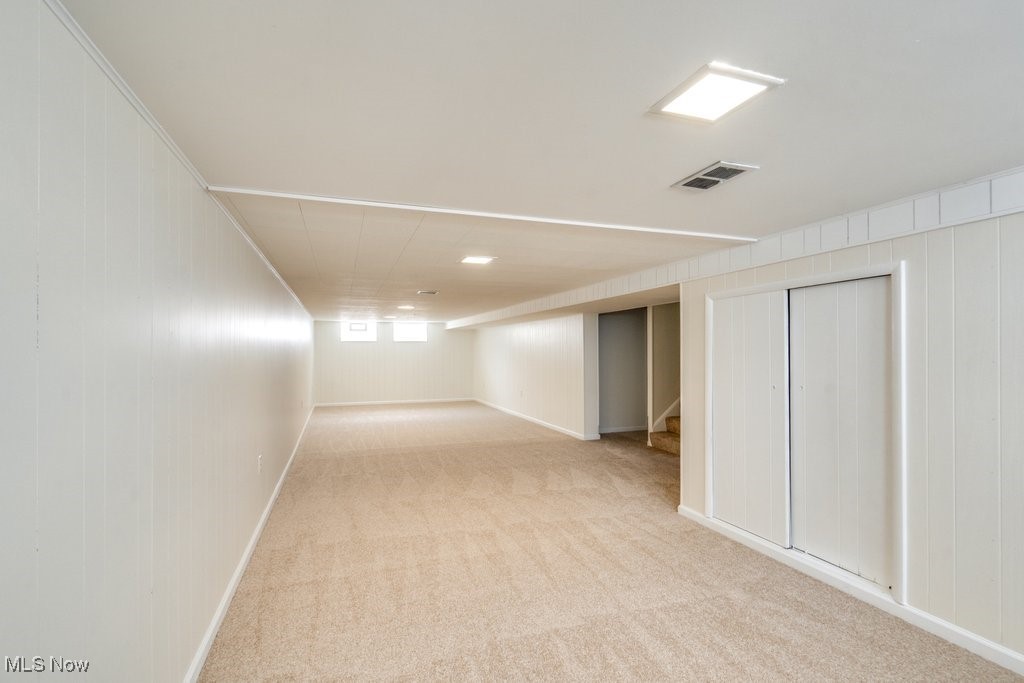 6961 Maplewood Road Parma Heights, OH 44130 - Photo 17 of 22 Basement featuring ornamental molding, wooden walls, and light colored carpet