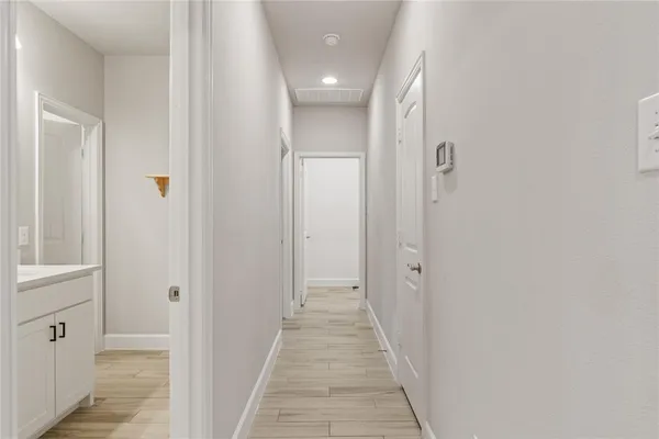 a view of a hallway with wooden floor and closet area