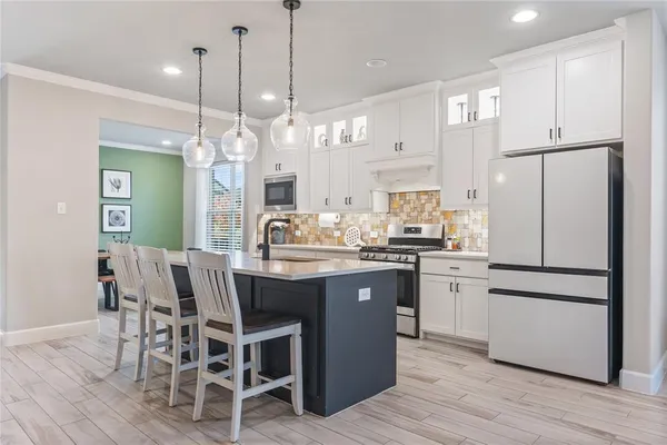a kitchen with kitchen island granite countertop a sink a center island and a refrigerator