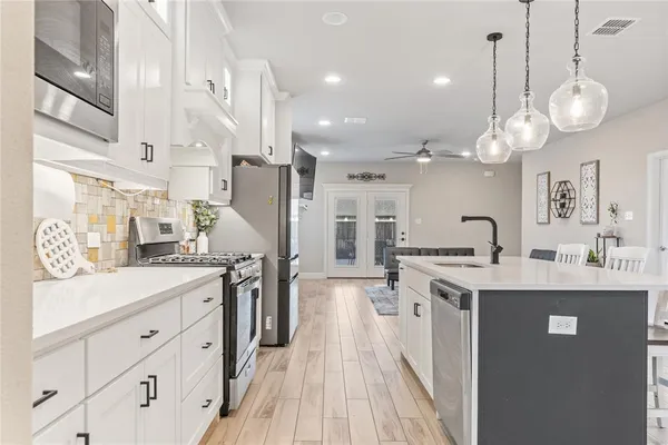 a large kitchen with cabinets and stainless steel appliances