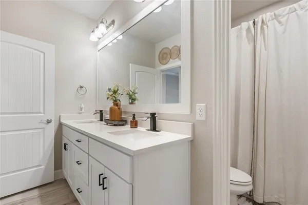 a bathroom with a sink a toilet and a mirror