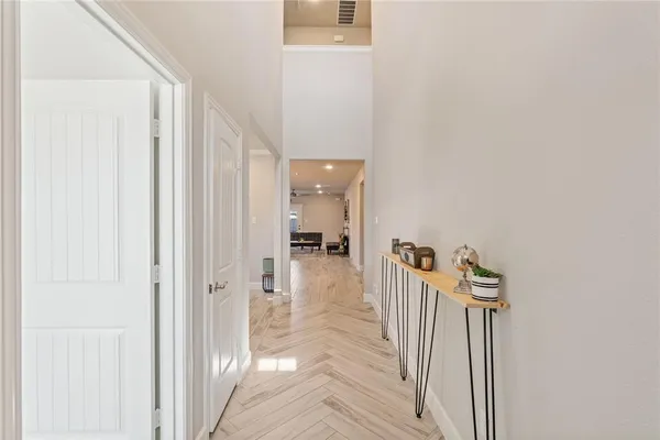 a view of a hallway with a livingroom and a chandelier