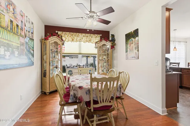 a dining room with furniture a chandelier and wooden floor