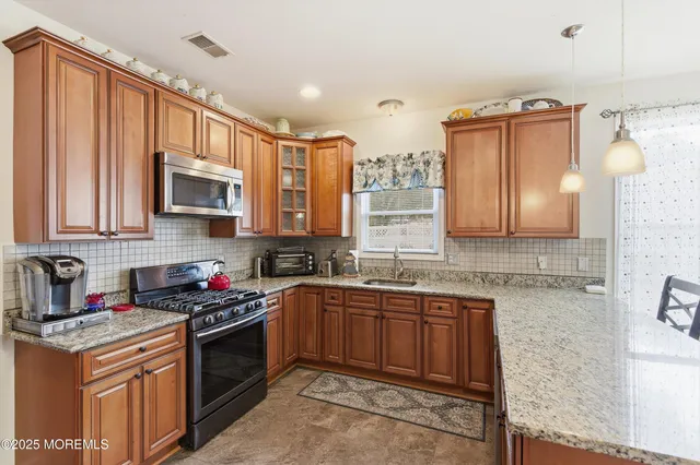 a kitchen with stainless steel appliances granite countertop a sink stove and microwave