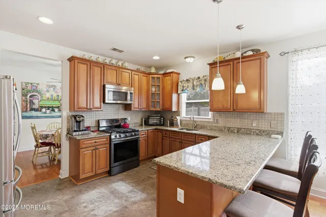 a kitchen with granite countertop a sink stove and cabinets