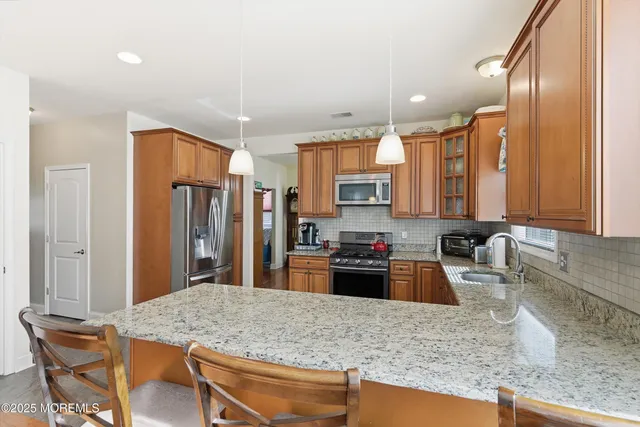 a kitchen with stainless steel appliances granite countertop a sink refrigerator and cabinets