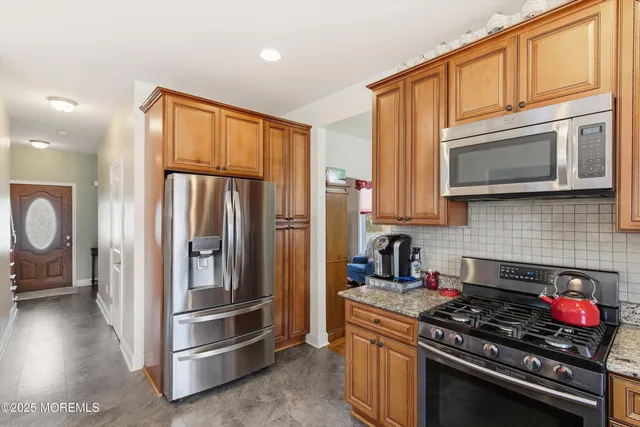 a kitchen with stainless steel appliances granite countertop a granite counter tops and a refrigerator