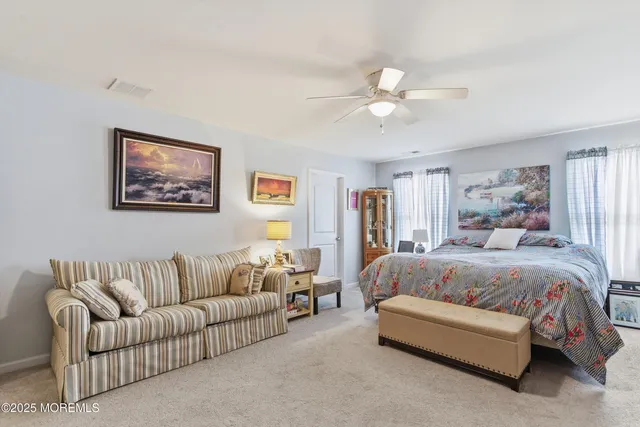 a spacious bedroom with a large bed couch and window