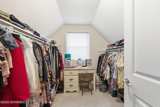 a view of walk in closet with clothes