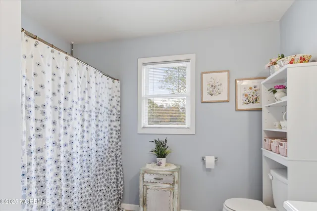 a bathroom with a sink a toilet and a window