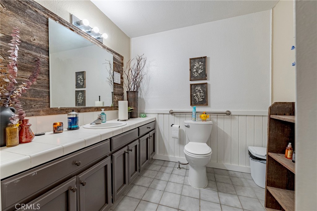 9387 Broadway Planada, CA 95365 - Photo 16 of 31 a bathroom with a sink a toilet and mirror