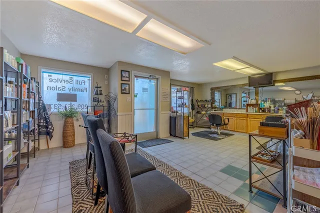 a living room with furniture a rug and kitchen view