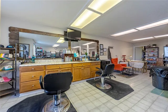 a living room with furniture a piano and a bookshelf