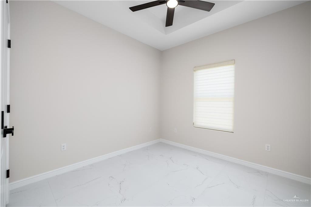 5335 Vision Street, Unit B Rio Grande City, TX 78582 - Photo 6 of 8 an empty room with a window and a ceiling fan