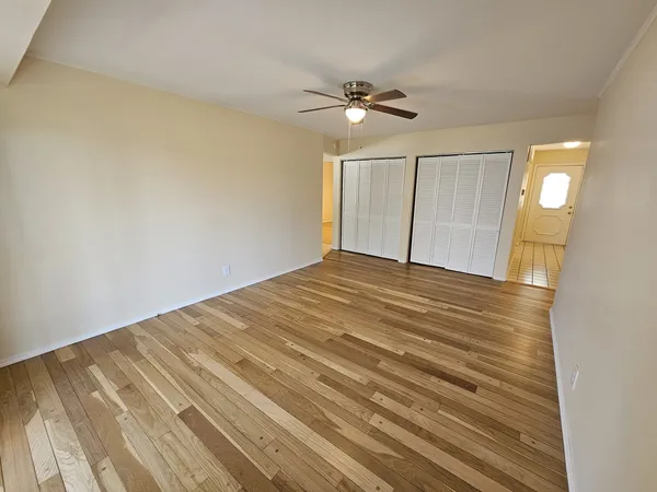 a view of empty room with wooden floor