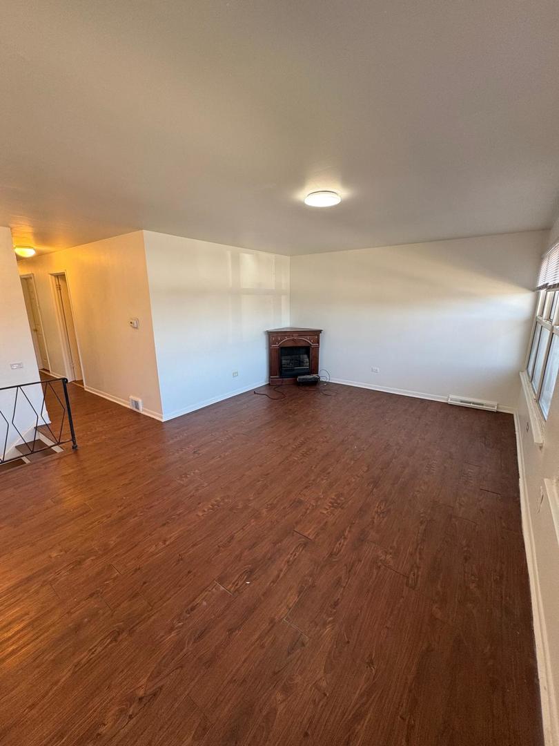 39 West 83rd Street Chicago, IL 60620 - Photo 5 of 12 an empty room with wooden floor and windows