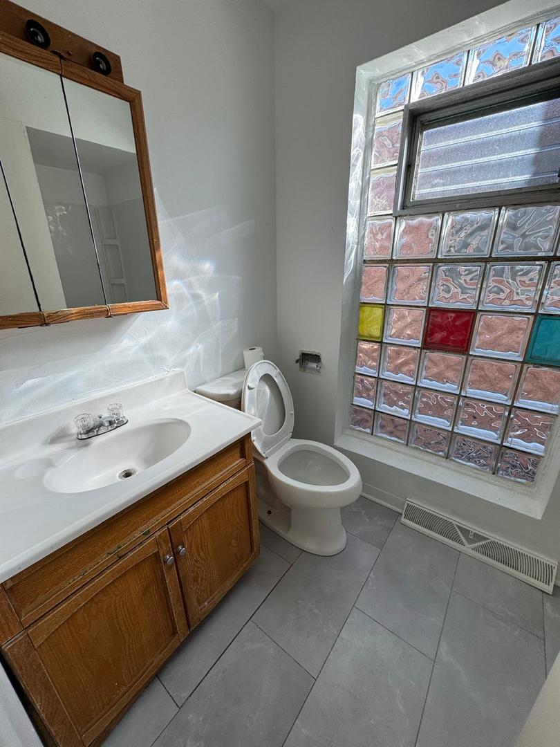 39 West 83rd Street Chicago, IL 60620 - Photo 7 of 12 a bathroom with a toilet sink and mirror