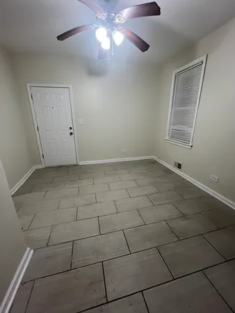 a view of an empty room with a chandelier fan