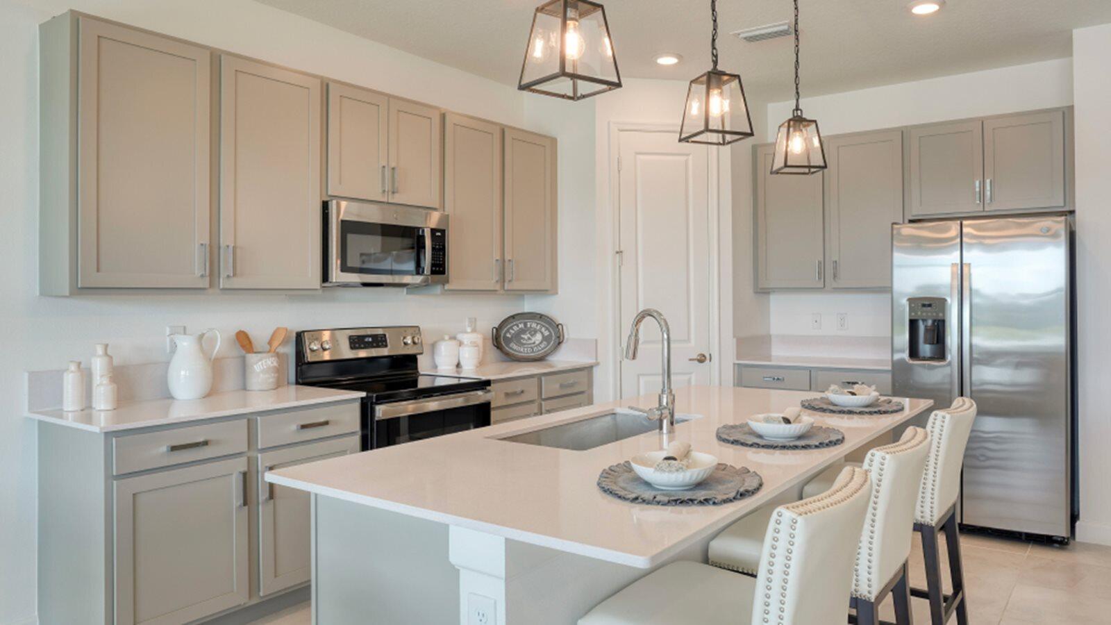 3611 Angler Drive Fort Pierce, FL 34946 - Photo 2 of 13 a kitchen with stainless steel appliances a table chairs and white cabinets