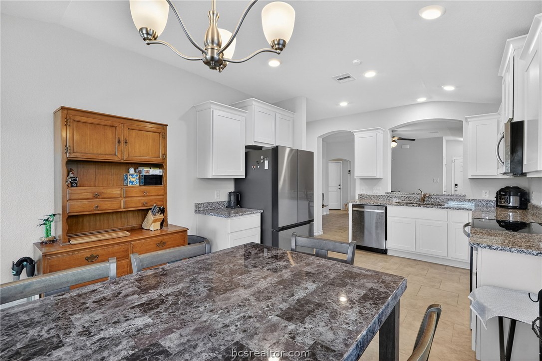 5235 Montague Loop Bryan, TX 77807 - Photo 8 of 25 a kitchen with stainless steel appliances granite countertop a sink a stove and a refrigerator