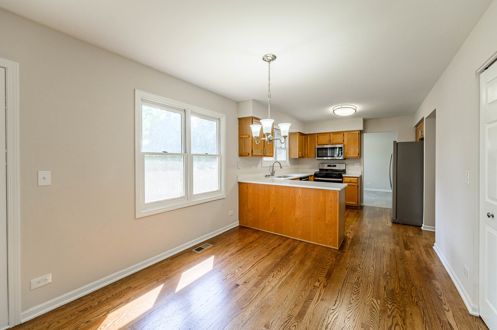 143 Hampton Street Cary, IL 60013 - Photo 6 of 19 a kitchen with stainless steel appliances granite countertop wooden floors and white cabinets