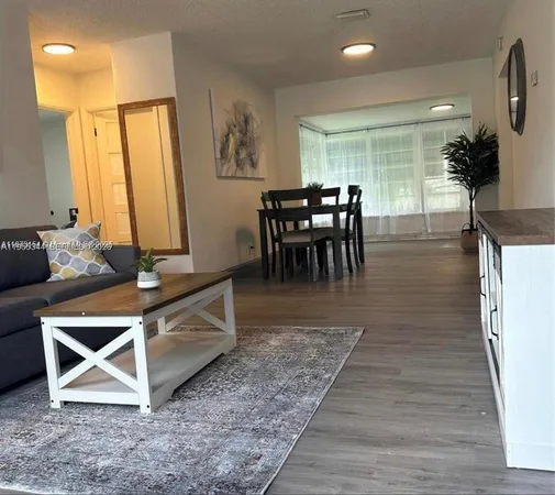 a living room with furniture a dining table and a large window