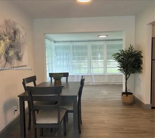 a view of a dining room with furniture and a potted plant