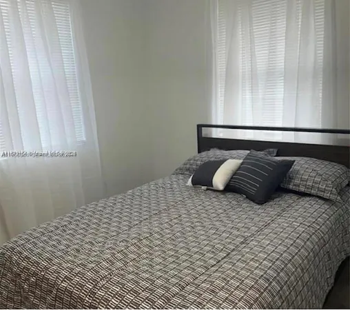 a large bed sitting in a bedroom next to a window
