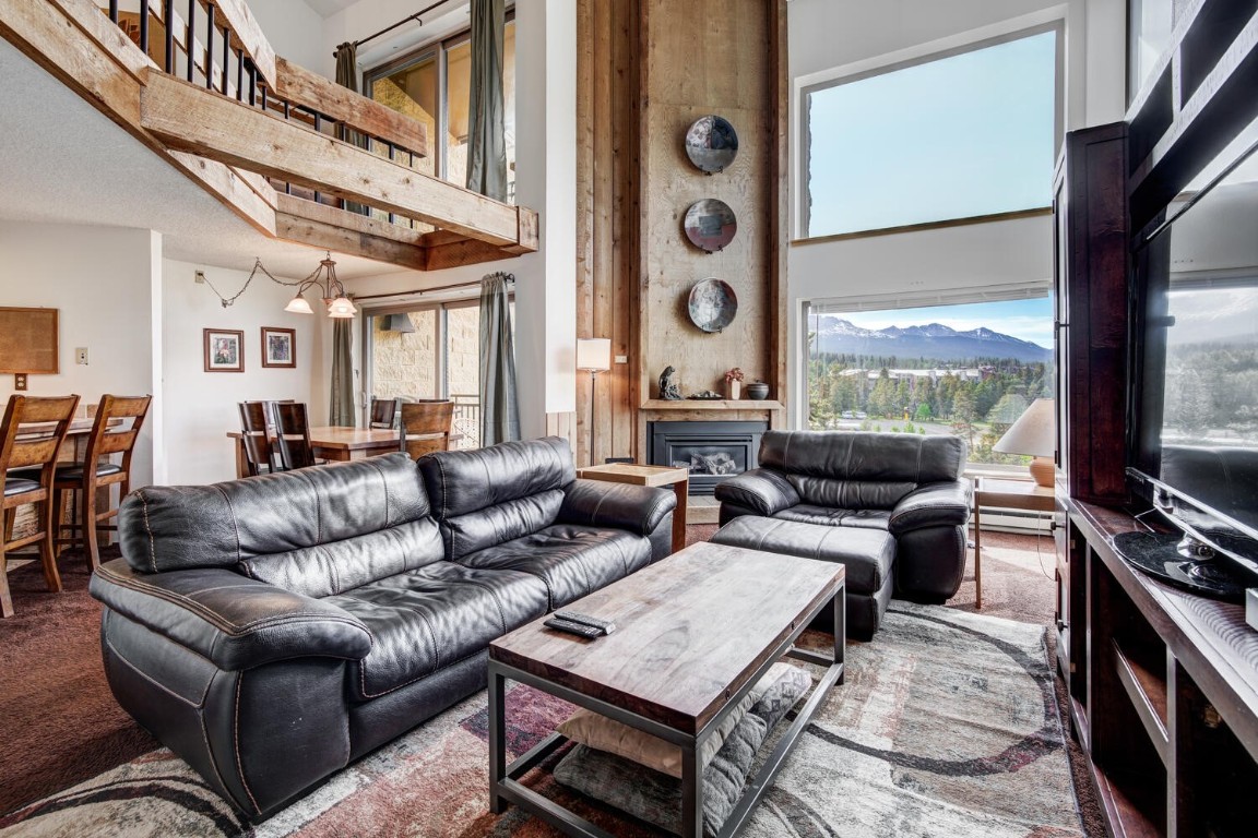 a living room with furniture a flat screen tv and a large window