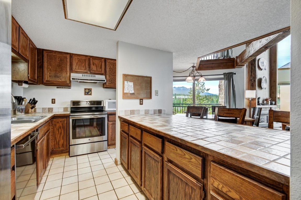 745 Columbine Road, Unit A404 Breckenridge, CO 80424 - Photo 12 of 32 a kitchen with stainless steel appliances granite countertop a stove a sink and a microwave