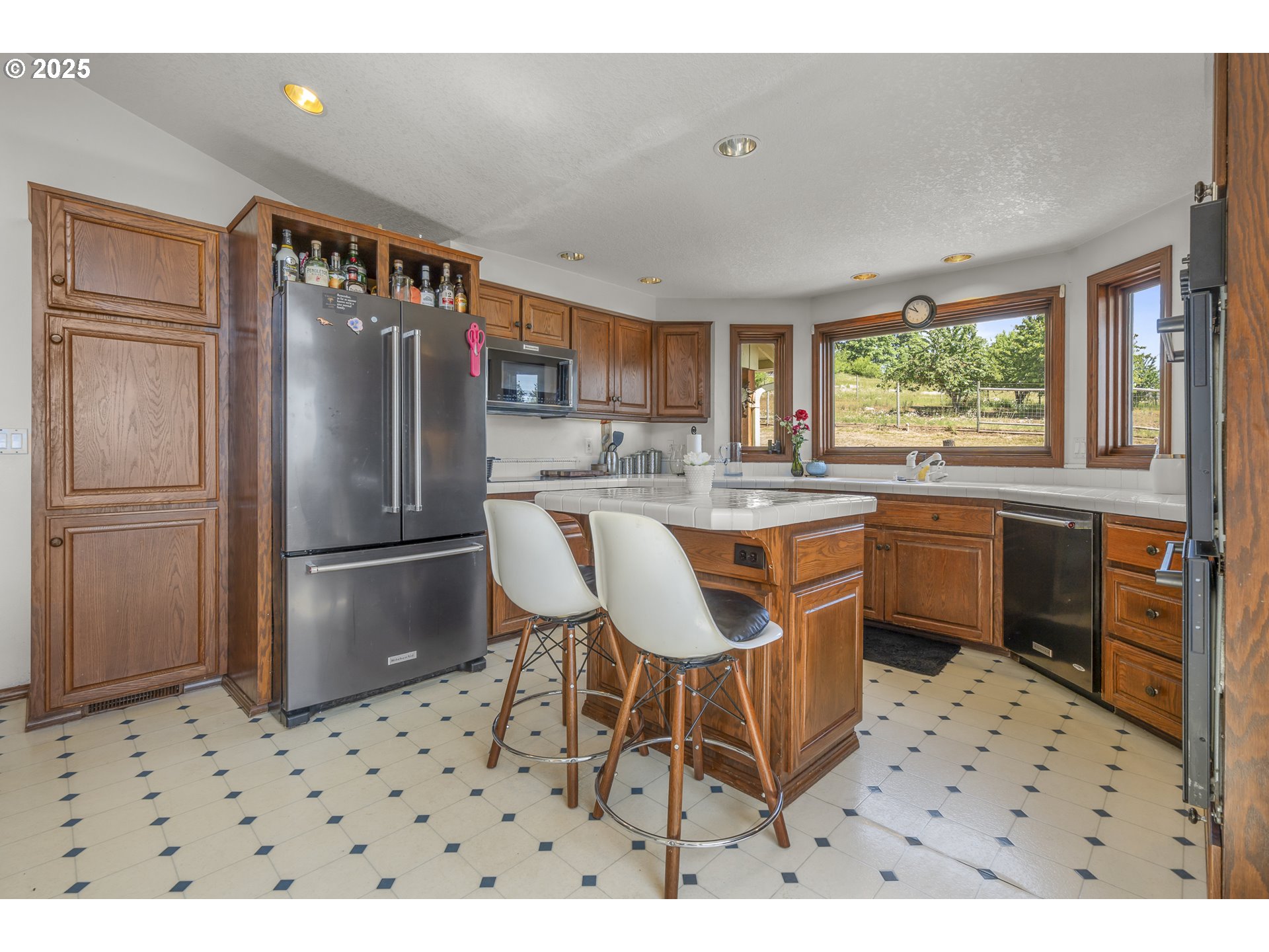 13900 Northwest Fir Crest Road McMinnville, OR 97128 - Photo 10 of 39 a kitchen with a refrigerator a sink a stove a dining table and chairs