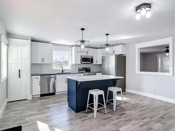 a kitchen with a sink a refrigerator a window and cabinets
