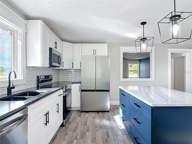 a kitchen with stainless steel appliances granite countertop a refrigerator and a stove top oven