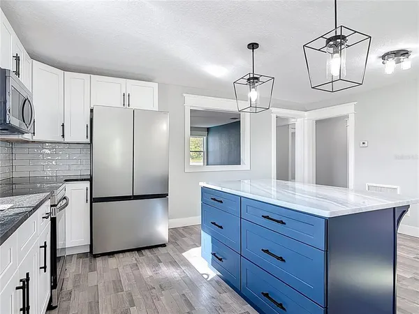 a bathroom with a granite countertop sink mirror and window