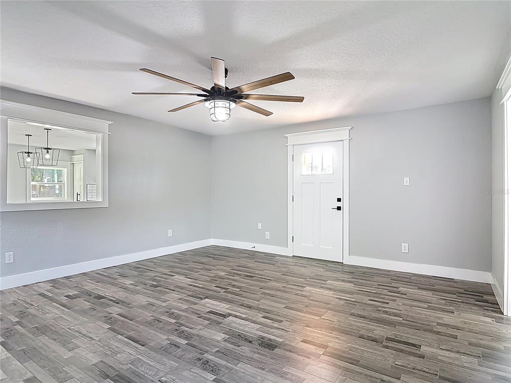 379 State Rte 415 Osteen, FL 32764 - Photo 28 of 48 a view of an empty room with wooden floor and a ceiling fan