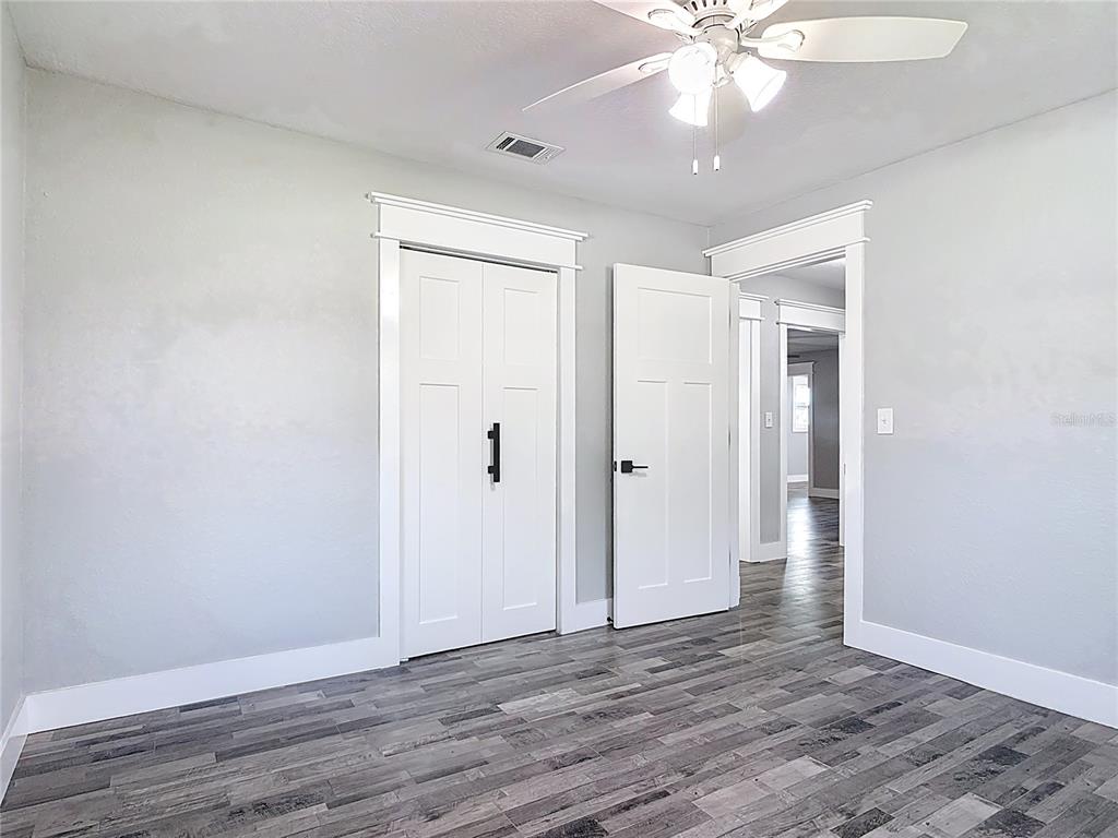 379 State Rte 415 Osteen, FL 32764 - Photo 31 of 48 an empty room with wooden floor and ceiling fan