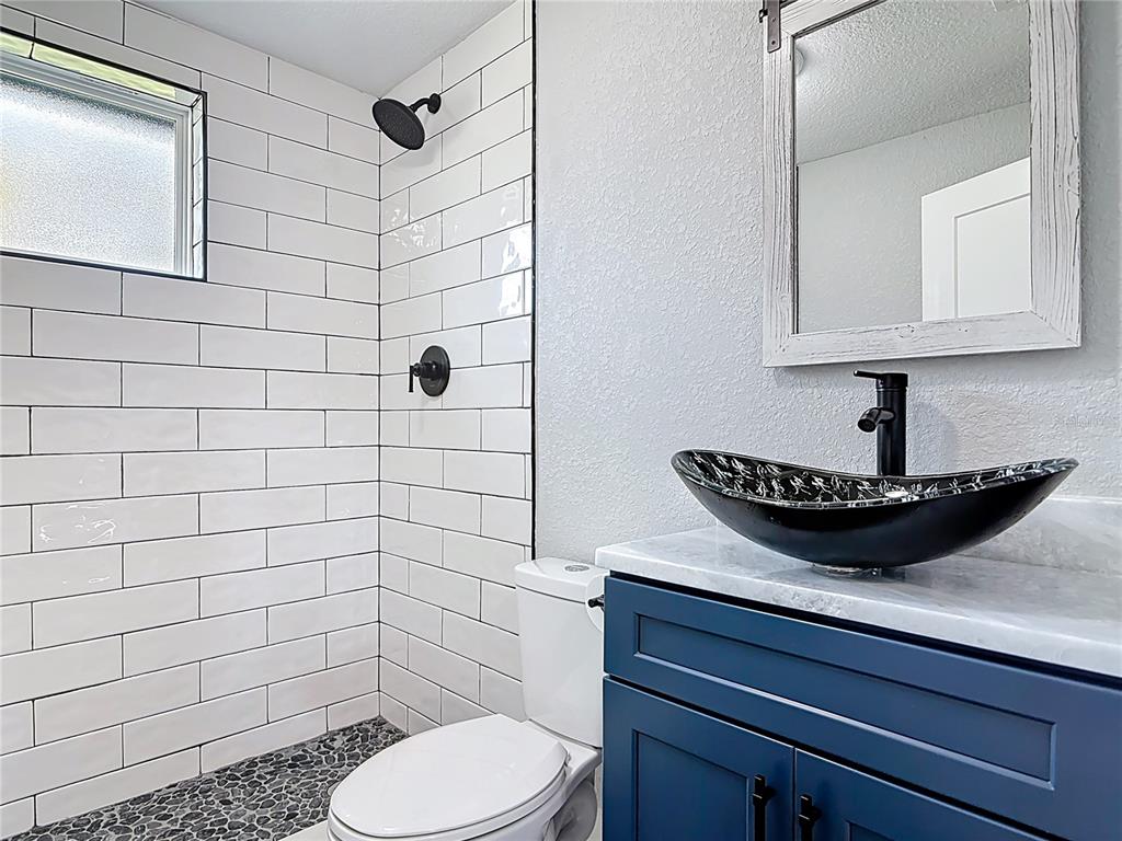 379 State Rte 415 Osteen, FL 32764 - Photo 41 of 48 a bathroom with a granite countertop toilet sink and mirror