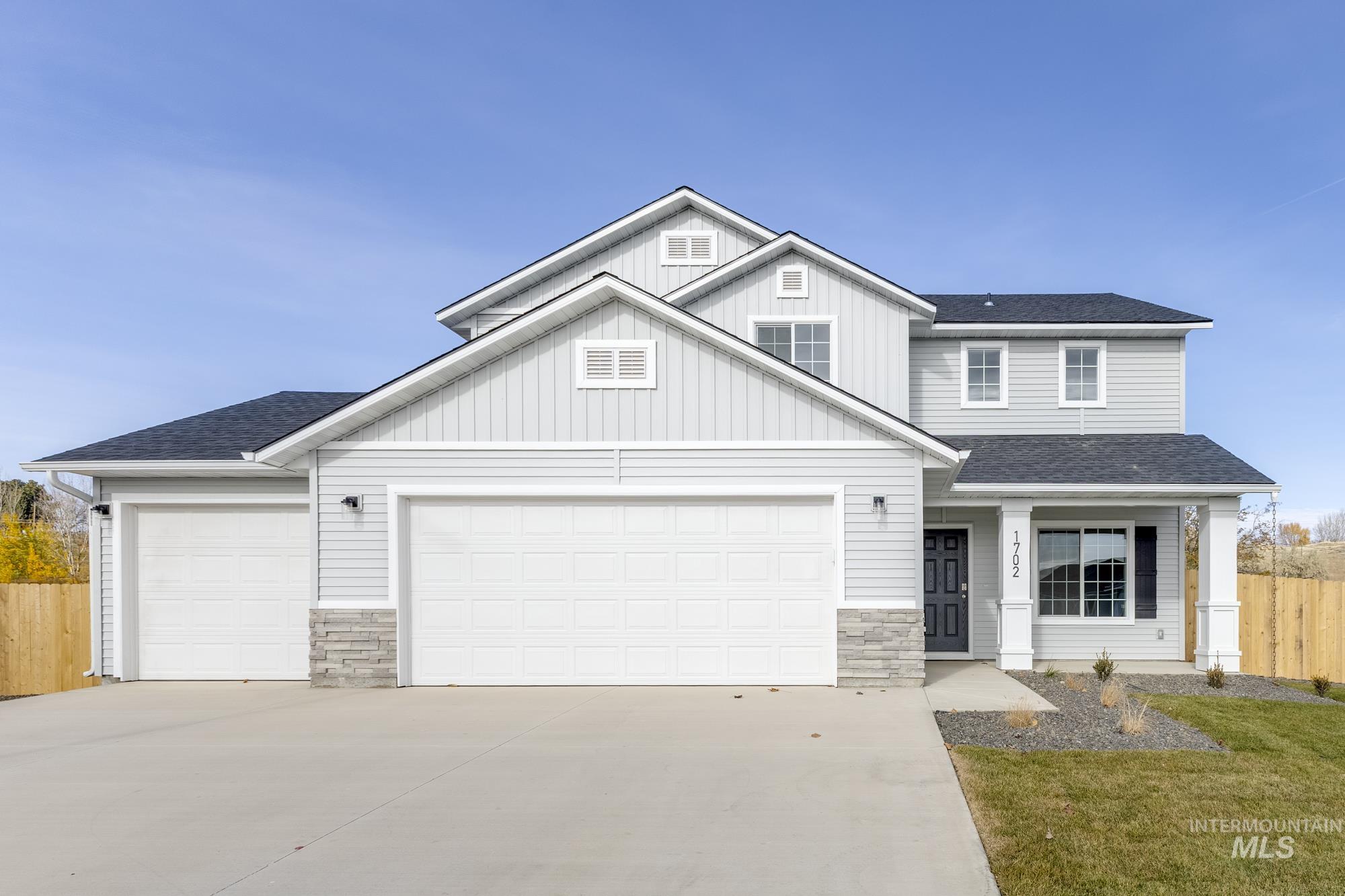 1702 Webb Brk Street Middleton, ID 83644 - Photo 1 of 21 View of front of property featuring a shingled roof, stone siding, board and batten siding, concrete driveway, and a porch