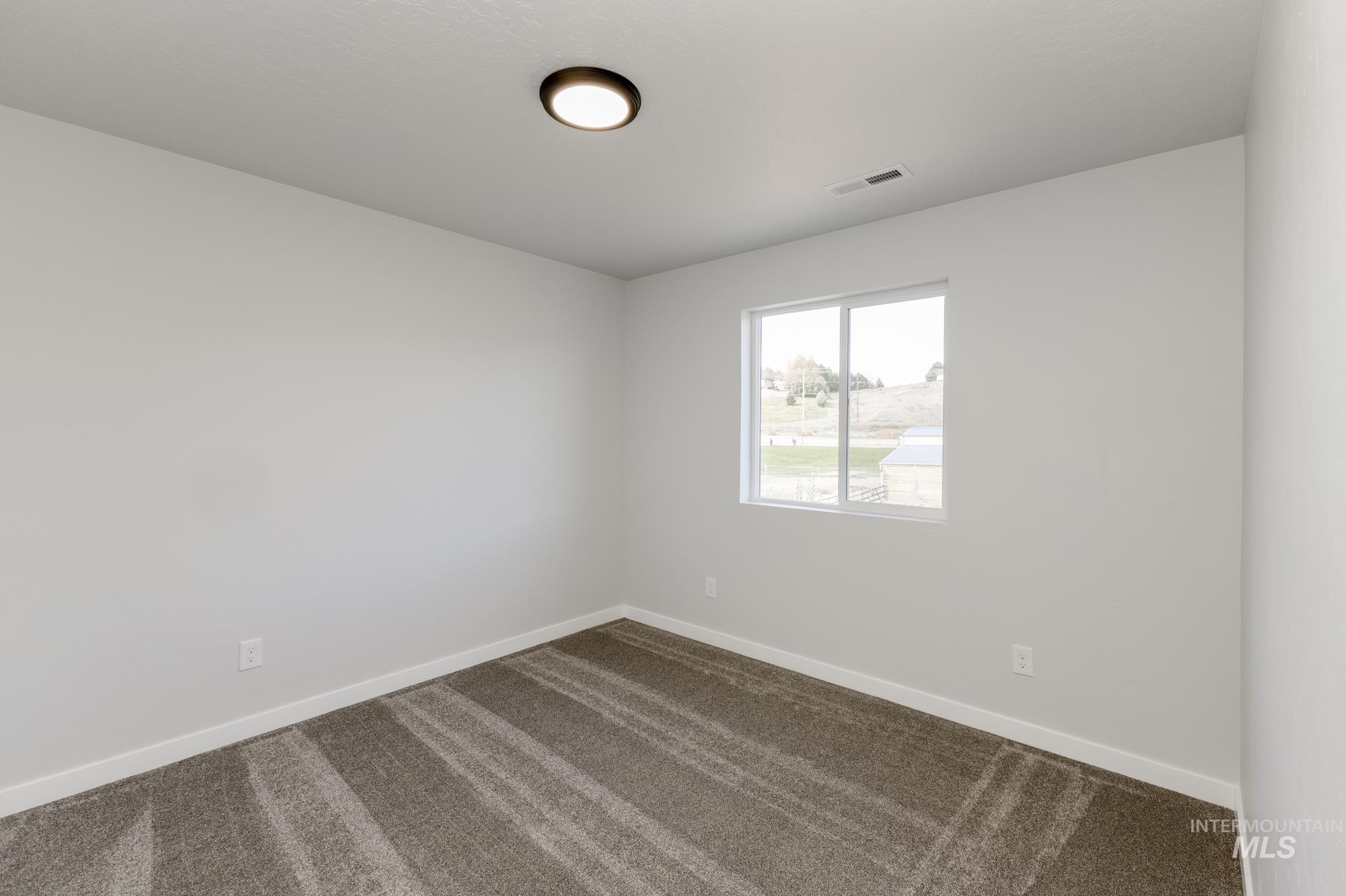 1702 Webb Brk Street Middleton, ID 83644 - Photo 12 of 21 Unfurnished room with dark colored carpet and baseboards