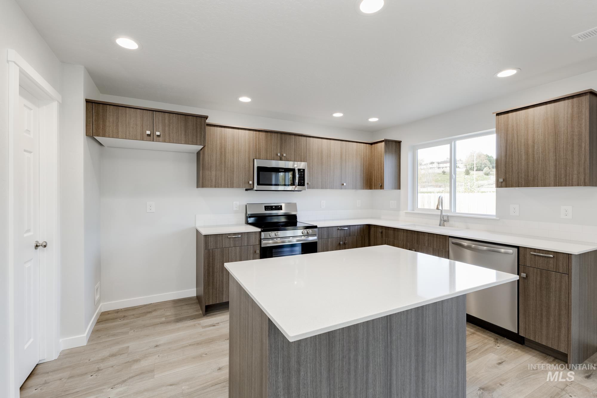 1702 Webb Brk Street Middleton, ID 83644 - Photo 3 of 21 Kitchen featuring appliances with stainless steel finishes, a center island, light wood-style floors, modern cabinets, and recessed lighting