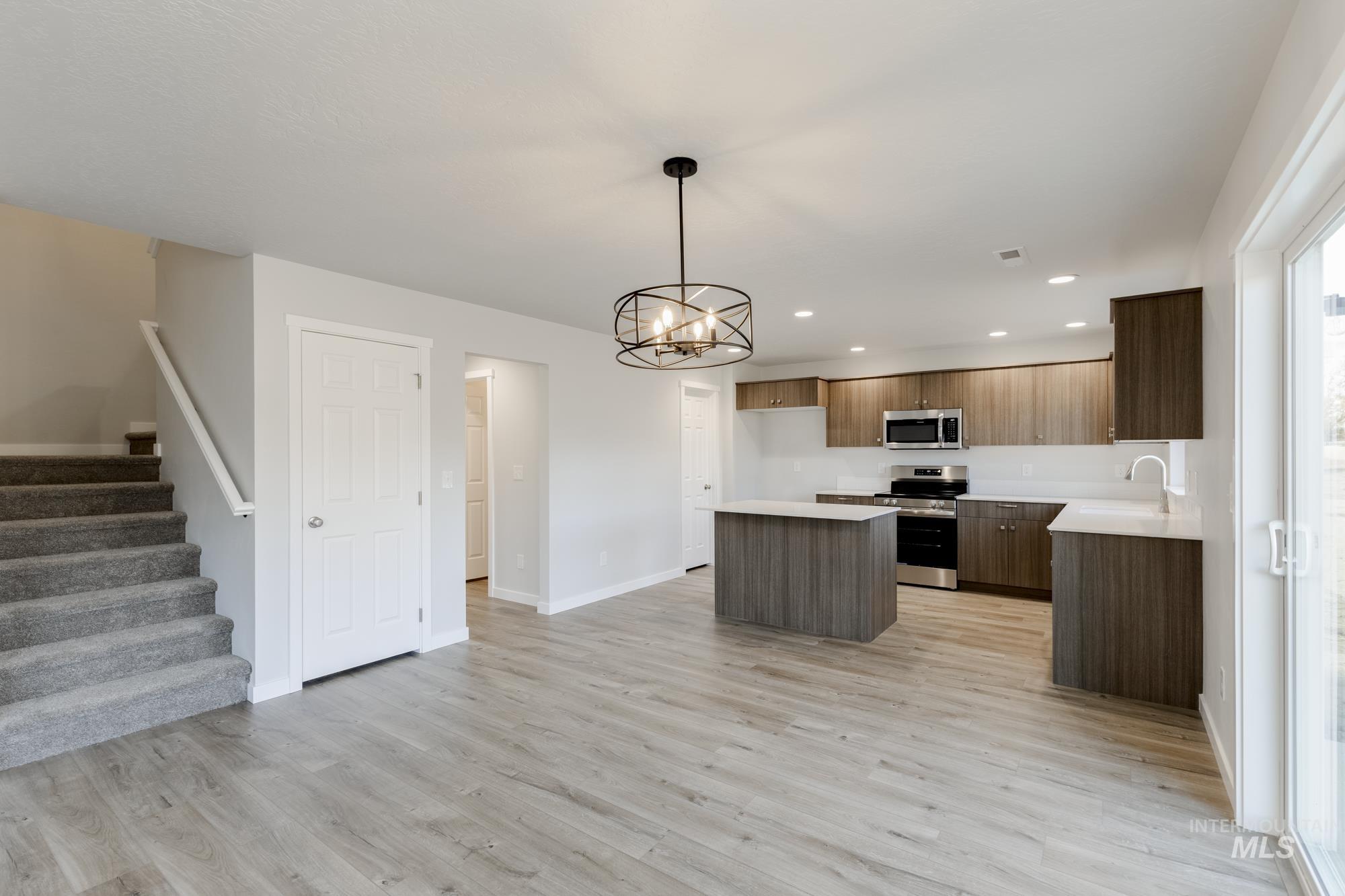 1702 Webb Brk Street Middleton, ID 83644 - Photo 6 of 21 Kitchen with a center island, light countertops, appliances with stainless steel finishes, hanging light fixtures, and a chandelier