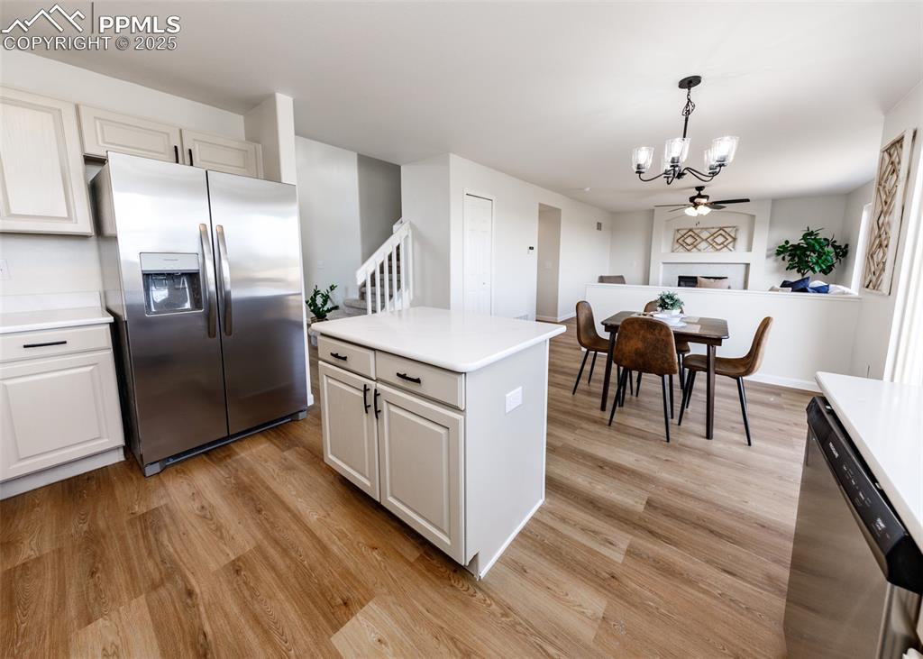 7715 Old Spec Road Peyton, CO 80831 - Photo 8 of 50 a kitchen with stainless steel appliances kitchen island granite countertop a table chairs and a refrigerator