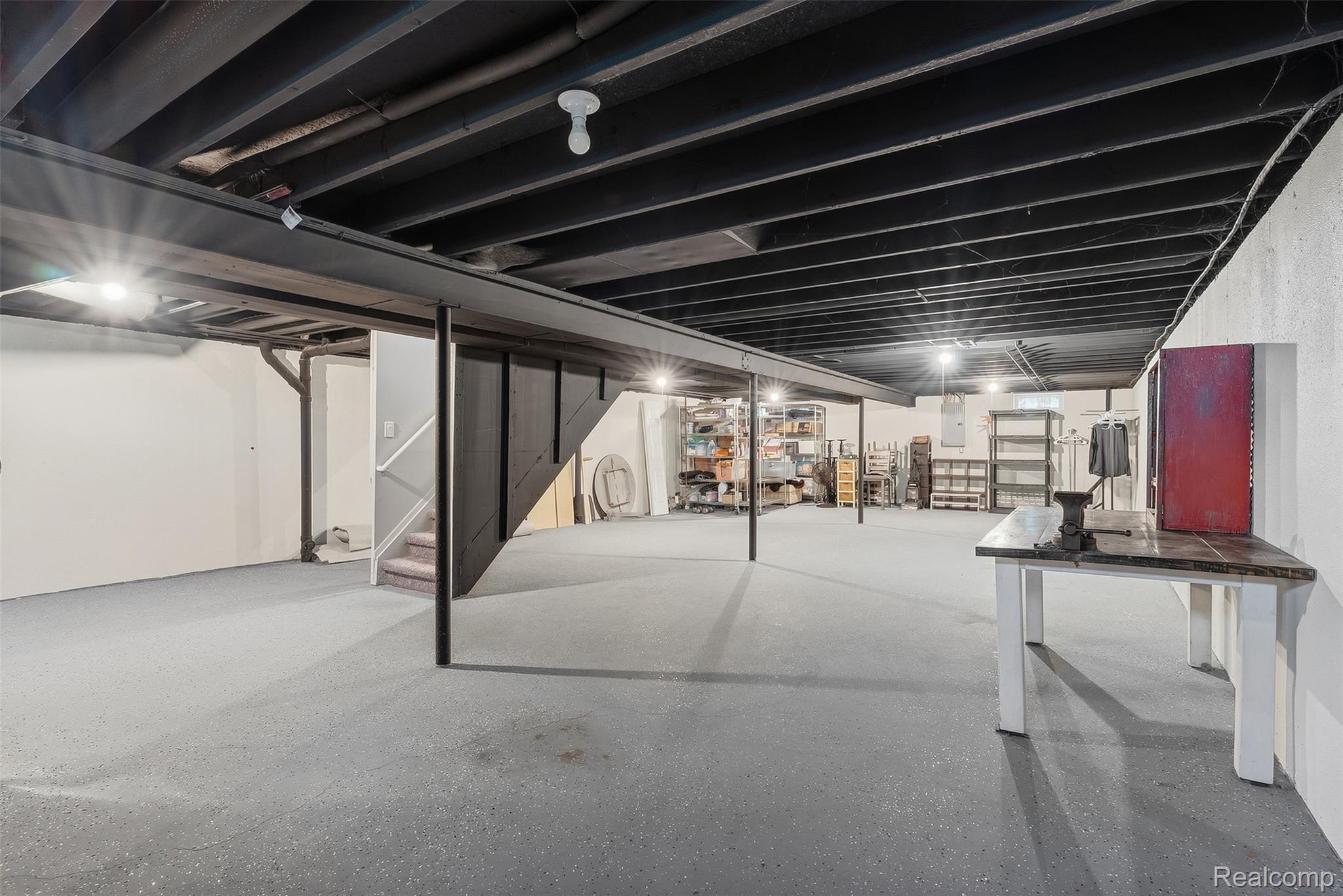 1750 Henbert Road West Bloomfield, MI 48324 - Photo 25 of 32 Expansive basement featuring exposed ceiling beams, painted concrete flooring, and a built-in staircase