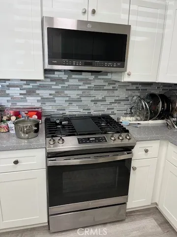 a kitchen with stainless steel appliances a stove and a microwave