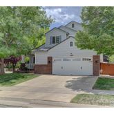 a view of a white house next to a yard and trees