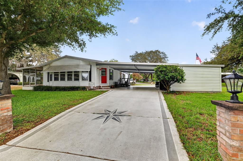 705 Devon Drive Lady Lake, FL 32159 - Photo 1 of 31 a front view of a house with a yard and potted plants