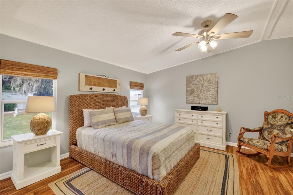 705 Devon Drive Lady Lake, FL 32159 - Photo 12 of 31 a bedroom with a bed and a chandelier